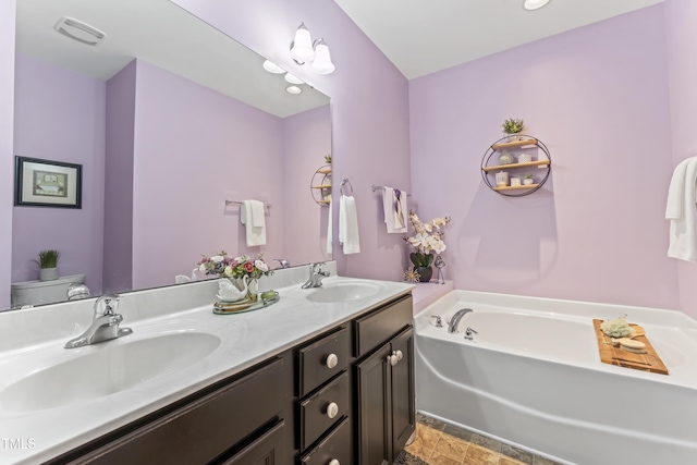 100 Beaconwood Ln, Holly Springs, NC 27540 - full bathroom featuring double vanity, a garden tub, and stone finish floors
