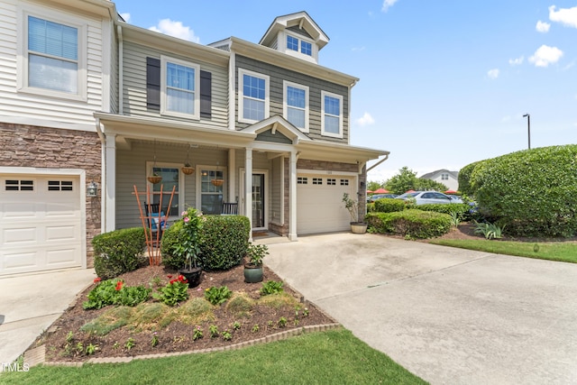 100 Beaconwood Ln, Holly Springs, NC 27540 - view of front of home featuring concrete driveway, a garage, covered porch, and stone siding