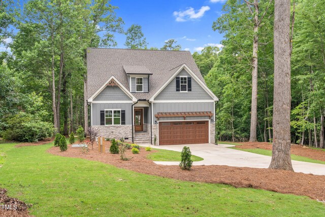 5504 Earle Rd, Raleigh, NC 27606 - craftsman inspired home featuring stone siding, concrete driveway, board and batten siding, a garage, and a front lawn