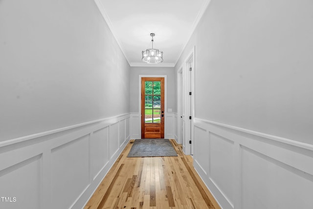 5504 Earle Rd, Raleigh, NC 27606 - entryway featuring ornamental molding, a chandelier, light wood-style flooring, wainscoting, and a decorative wall