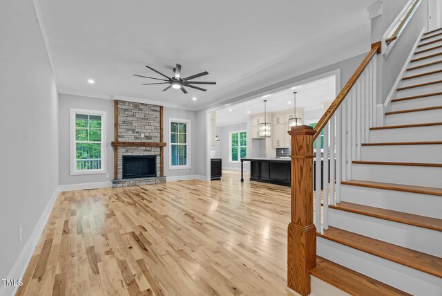 5504 Earle Rd, Raleigh, NC 27606 - unfurnished living room featuring ceiling fan, light wood-style floors, plenty of natural light, recessed lighting, and crown molding