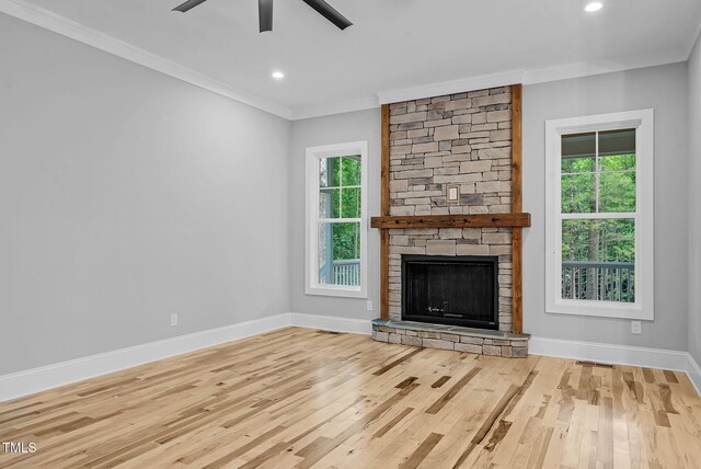 5504 Earle Rd, Raleigh, NC 27606 - unfurnished living room featuring ceiling fan, crown molding, plenty of natural light, wood finished floors, and a fireplace