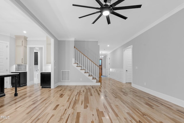 5504 Earle Rd, Raleigh, NC 27606 - unfurnished living room with ornamental molding, stairs, a ceiling fan, light wood-style floors, and recessed lighting