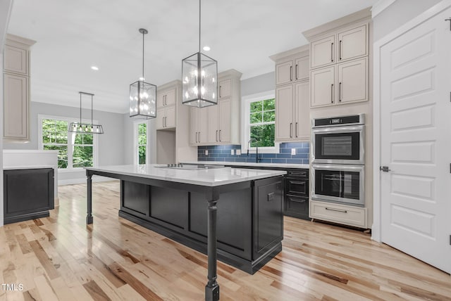 5504 Earle Rd, Raleigh, NC 27606 - kitchen featuring stainless steel double oven, light countertops, light wood-style floors, decorative backsplash, and a kitchen breakfast bar
