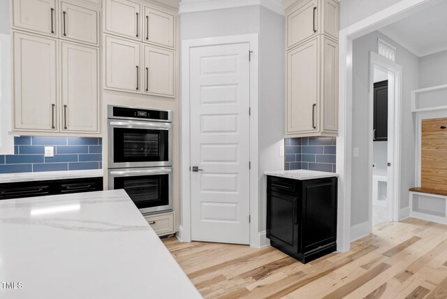 5504 Earle Rd, Raleigh, NC 27606 - kitchen with double oven, light wood-type flooring, backsplash, and light stone countertops