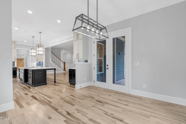 5504 Earle Rd, Raleigh, NC 27606 - kitchen featuring dark cabinetry, light wood finished floors, recessed lighting, light countertops, and a chandelier
