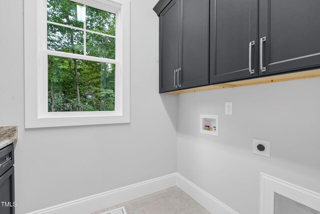 5504 Earle Rd, Raleigh, NC 27606 - washroom with cabinet space, electric dryer hookup, hookup for a washing machine, and light tile patterned floors