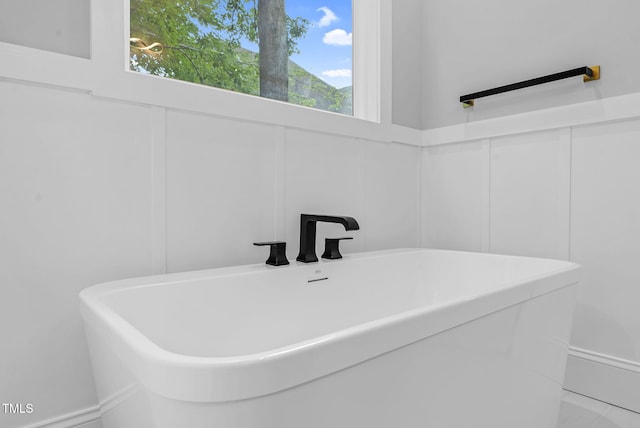 5504 Earle Rd, Raleigh, NC 27606 - bathroom featuring a freestanding bath and a decorative wall