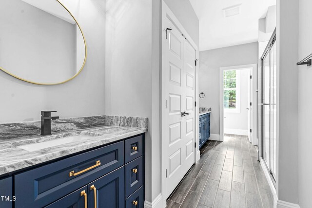 5504 Earle Rd, Raleigh, NC 27606 - full bathroom with vanity, a shower stall, and wood finished floors