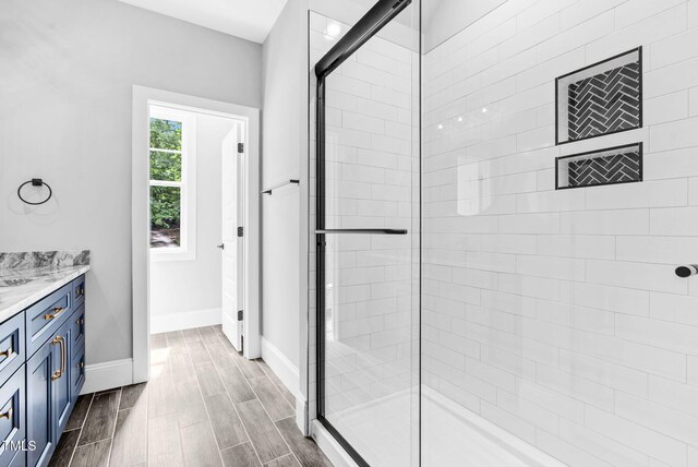 5504 Earle Rd, Raleigh, NC 27606 - full bath with tiled shower, vanity, and wood finished floors