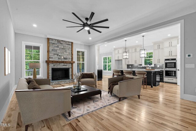 5504 Earle Rd, Raleigh, NC 27606 - living room featuring light wood-style floors, ornamental molding, healthy amount of natural light, a ceiling fan, and recessed lighting