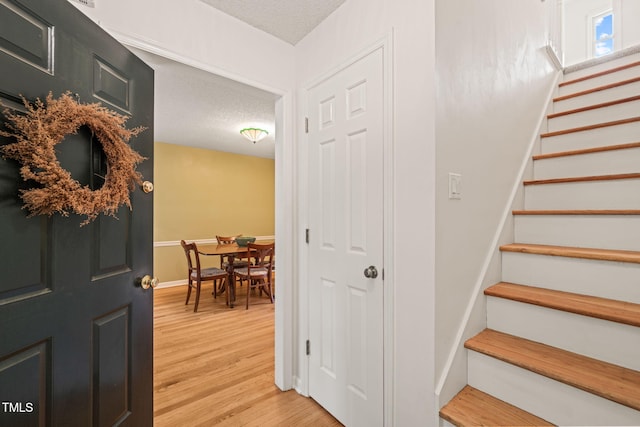 20 Timberlyne Rd, Chapel Hill, NC 27514 - foyer entrance with stairway, a textured ceiling, light wood-style flooring, and baseboards