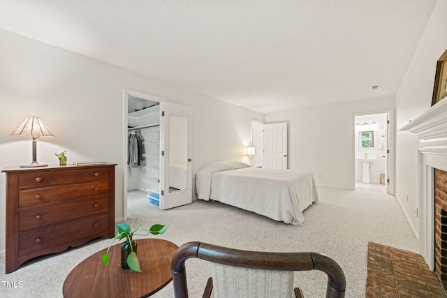 20 Timberlyne Rd, Chapel Hill, NC 27514 - bedroom with carpet floors, a brick fireplace, ensuite bath, a textured ceiling, and a spacious closet