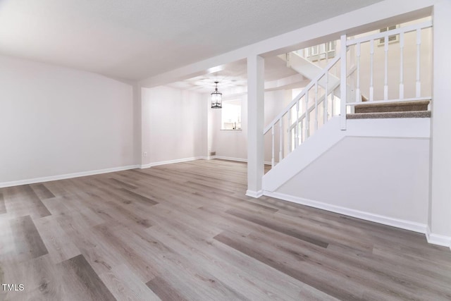 404 Shannonford Ct, Wake Forest, NC 27587 - unfurnished living room with stairs, wood finished floors, baseboards, and a chandelier