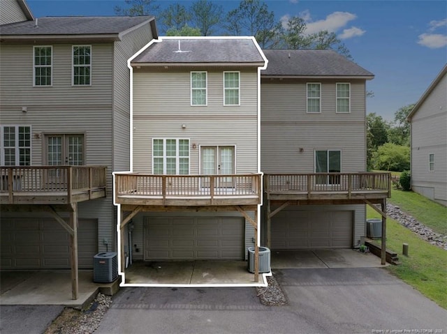 427 Georgetown Cir, Fayetteville, NC 28314 - back of house featuring an attached garage, central AC unit, and asphalt driveway