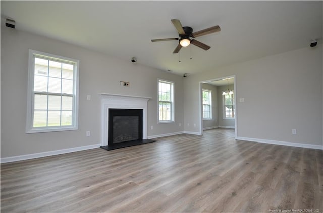 479 Broad Dr, Raeford, NC 28376 - unfurnished living room featuring wood finished floors, a ceiling fan, a glass covered fireplace, and baseboards