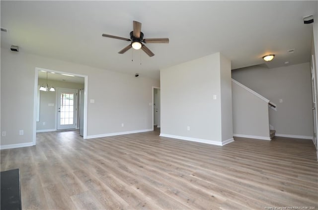 479 Broad Dr, Raeford, NC 28376 - unfurnished living room with ceiling fan, light wood finished floors, a chandelier, baseboards, and stairway