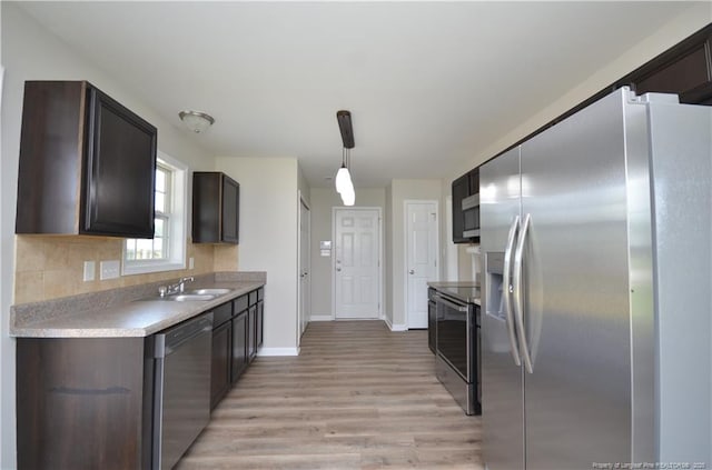 479 Broad Dr, Raeford, NC 28376 - kitchen with appliances with stainless steel finishes, light wood finished floors, light countertops, a sink, and dark brown cabinets