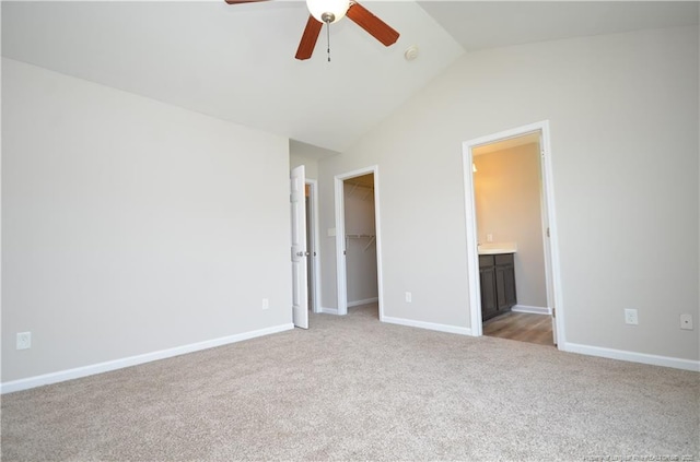 479 Broad Dr, Raeford, NC 28376 - unfurnished bedroom with light colored carpet, a walk in closet, lofted ceiling, a closet, and baseboards