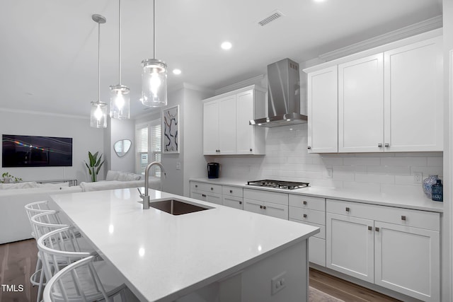 8415 Zinc Autumn Path, Raleigh, NC 27615 - kitchen with wall chimney range hood, a sink, ornamental molding, open floor plan, and stainless steel gas cooktop