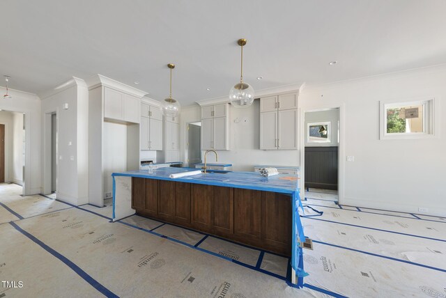 1225 Dixie Trl, Raleigh, NC 27607 - kitchen featuring ornamental molding, white cabinets, a large island, and hanging light fixtures