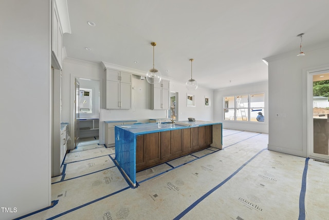 1225 Dixie Trl, Raleigh, NC 27607 - kitchen with a center island with sink, decorative light fixtures, white cabinetry, and crown molding