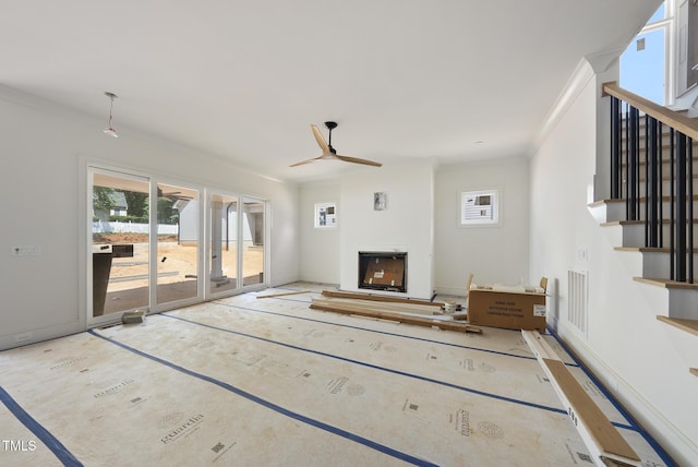 1225 Dixie Trl, Raleigh, NC 27607 - unfurnished living room with healthy amount of natural light, ceiling fan, ornamental molding, a fireplace, and stairway
