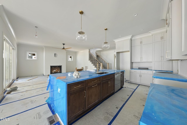 1225 Dixie Trl, Raleigh, NC 27607 - kitchen featuring white cabinets, dark brown cabinetry, ceiling fan, and an island with sink