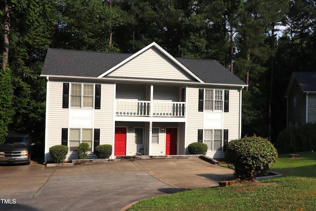 2204 Caroline Dr, Durham, NC 27705 - view of front facade with a balcony, roof with shingles, a porch, and view of wooded area