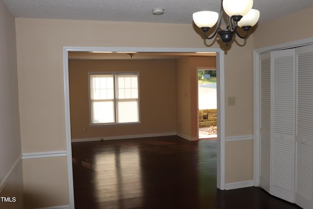 2204 Caroline Dr, Durham, NC 27705 - unfurnished dining area featuring a chandelier, dark wood finished floors, healthy amount of natural light, and a textured ceiling
