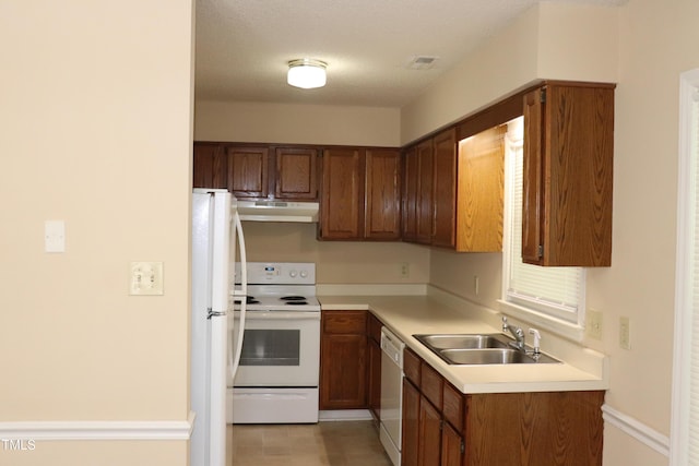 2204 Caroline Dr, Durham, NC 27705 - kitchen featuring white appliances, under cabinet range hood, light countertops, and brown cabinets