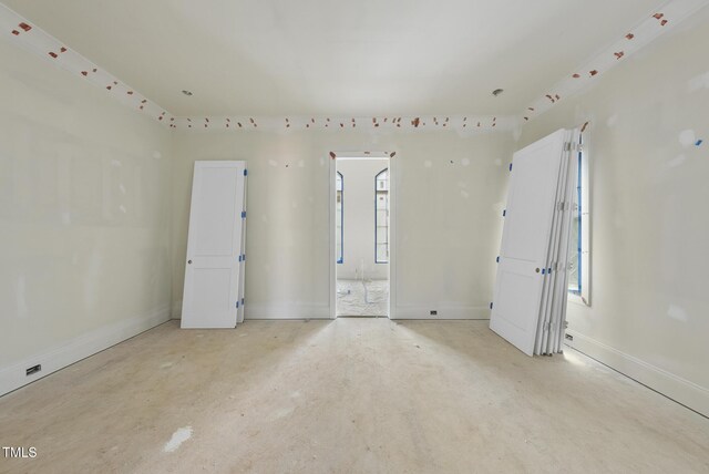 1221 Dixie Trl, Raleigh, NC 27607 - spare room with unfinished concrete flooring and plenty of natural light