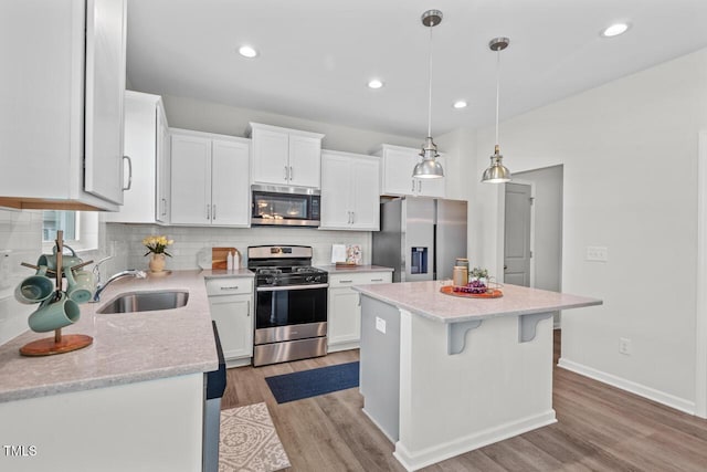 509 Rain Drizzle Ct, Wake Forest, NC 27587 - kitchen with stainless steel appliances, light wood-type flooring, a kitchen island, white cabinetry, and decorative backsplash