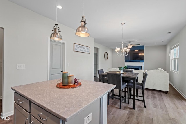509 Rain Drizzle Ct, Wake Forest, NC 27587 - kitchen with light wood-style floors, a center island, hanging light fixtures, light countertops, and recessed lighting
