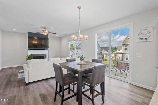 509 Rain Drizzle Ct, Wake Forest, NC 27587 - dining space featuring wood finished floors, a ceiling fan, a fireplace, recessed lighting, and a chandelier