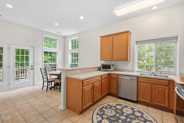 1406 Pebble Creek Xing, Durham, NC 27713 - kitchen featuring appliances with stainless steel finishes, a peninsula, light tile patterned floors, light countertops, and recessed lighting