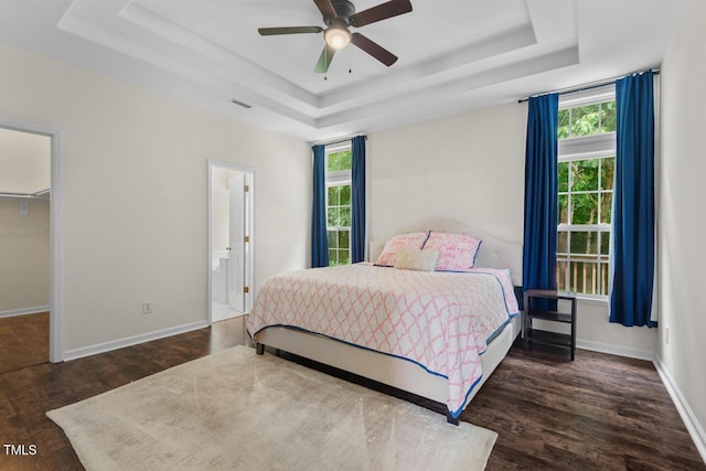 1406 Pebble Creek Xing, Durham, NC 27713 - bedroom featuring a raised ceiling, wood finished floors, a spacious closet, connected bathroom, and a ceiling fan