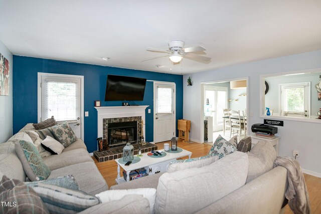1008 Catsby Cir, Raleigh, NC 27603 - living room featuring a ceiling fan, wood finished floors, and a fireplace with raised hearth