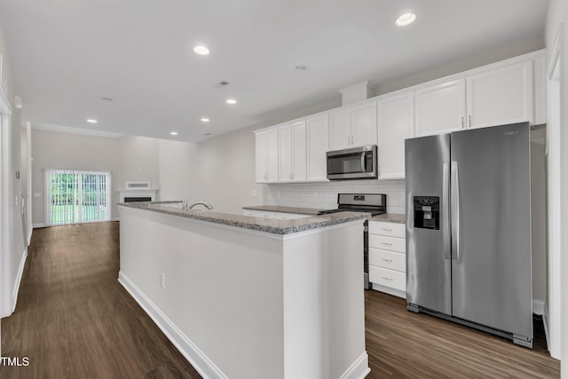 656 Barneswyck Dr, Fuquay Varina, NC 27526 - kitchen with stainless steel appliances, dark wood-style flooring, white cabinetry, an island with sink, and backsplash