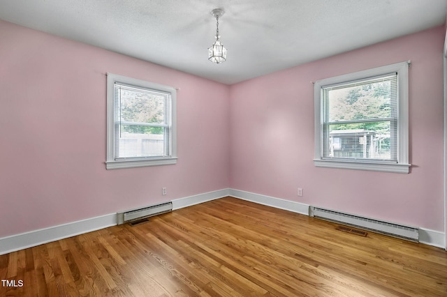 106 Grace Dr NW, Wilson, NC 27896 - unfurnished room with baseboard heating, wood finished floors, baseboards, and a baseboard radiator