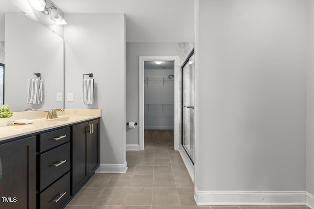 509 Holden Forest Dr, Youngsville, NC 27596 - full bath featuring vanity, a stall shower, tile patterned flooring, and a walk in closet