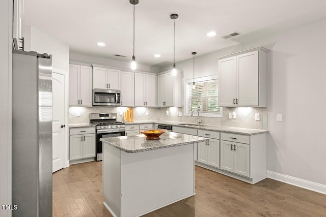 509 Holden Forest Dr, Youngsville, NC 27596 - kitchen with stainless steel appliances, light wood-style flooring, tasteful backsplash, white cabinetry, and recessed lighting