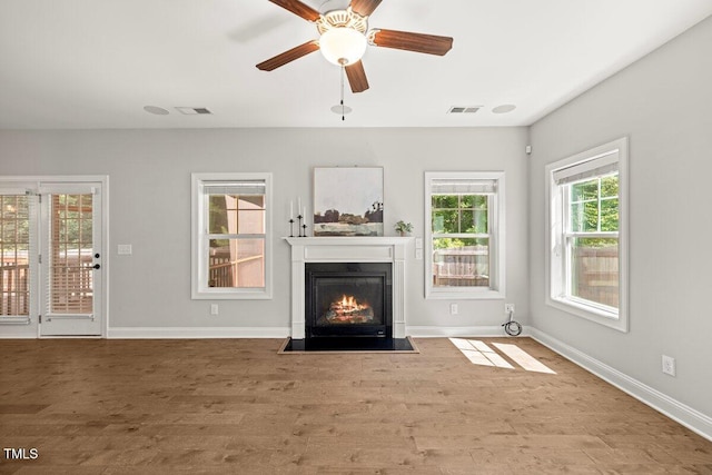 509 Holden Forest Dr, Youngsville, NC 27596 - unfurnished living room with a fireplace with flush hearth, wood finished floors, and a ceiling fan
