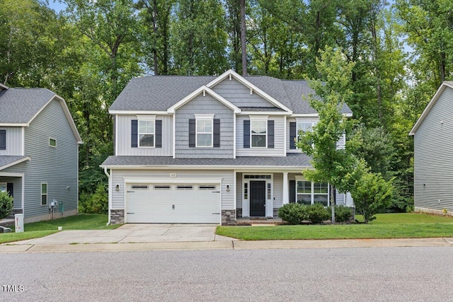 509 Holden Forest Dr, Youngsville, NC 27596 - craftsman-style house with driveway, stone siding, an attached garage, a front yard, and covered porch
