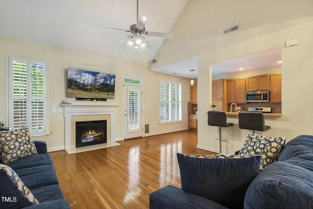 2311 Woodwyck Way, Raleigh, NC 27604 - living room featuring light wood-style floors, a ceiling fan, a fireplace with flush hearth, and lofted ceiling