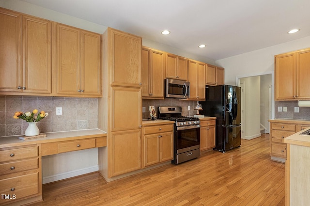 2311 Woodwyck Way, Raleigh, NC 27604 - kitchen featuring appliances with stainless steel finishes, built in study area, tasteful backsplash, light wood-style flooring, and light countertops