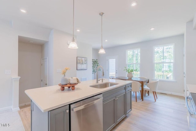 1359 Chowan Ave, Durham, NC 27713 - kitchen featuring dishwasher, gray cabinets, light wood-style flooring, an island with sink, and light countertops