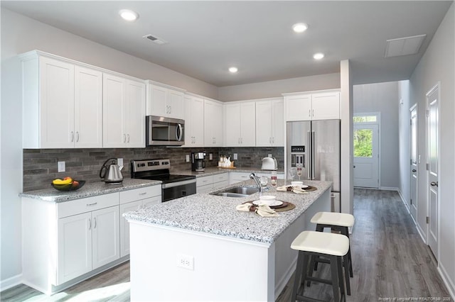694 Union St, Home, Raeford, NC 28376 - kitchen featuring stainless steel appliances, white cabinetry, light wood-type flooring, tasteful backsplash, and recessed lighting