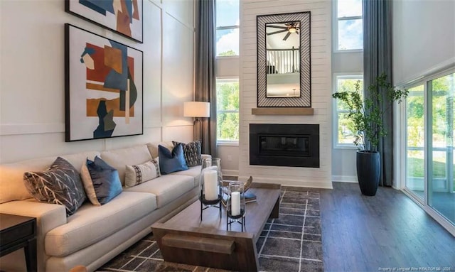 694 Union St, Home, Raeford, NC 28376 - living area featuring a fireplace, wood finished floors, a towering ceiling, and a ceiling fan