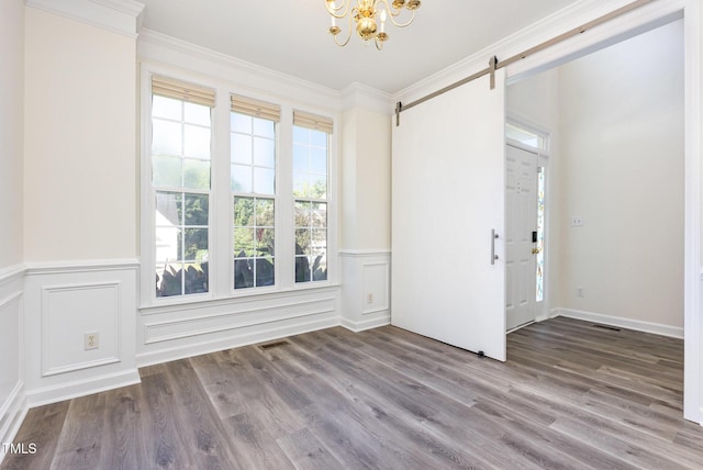 1613 Patterson Grove Rd, Apex, NC 27502 - unfurnished room featuring a chandelier, a barn door, wood finished floors, wainscoting, and ornamental molding